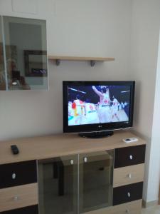 a flat screen tv sitting on top of a wooden table at Apartamentos Danesp La Ribera Torrelasal - Marina Dor in Oropesa del Mar