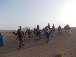 Bivouac Draa في زاكورة: مجموعة من الناس يركبون الخيول على طريق ترابي