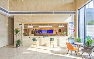 a reception area in a building with chairs and tables at GreenTree Inn Tongxiang Chongfuzhen World Fur Center Branch in Gaoyang