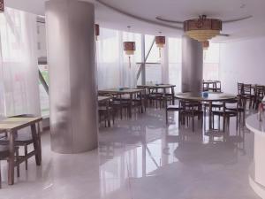 a dining room with tables and chairs and windows at GreenTree Inn Binzhou Bus Station in Dudian
