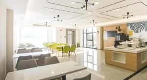 HudaiにあるGreenTree Inn Express Taizhou Jiangyan Hardware Cityのテーブルと椅子のあるダイニングルームとキッチン