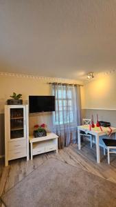 a living room with a tv and a table at Am Obstgarten in Hinte
