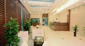a lobby with white furniture and plants in a building at Shijia Inn On the Bund in Shanghai