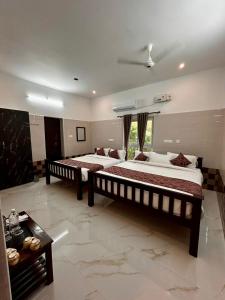 a large bedroom with two beds and a table at LuXus Resort & Swimming Pool in Pondicherry +35 photos