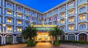 Un gran edificio con un cartel delante. en Roung Nakhone Vang Vieng Hotel, en Vang Vieng