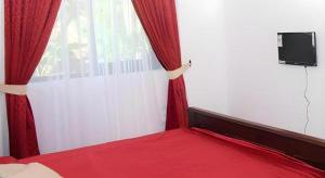 a bedroom with a red bed and a window at The MGS Hotel in Kadirandola