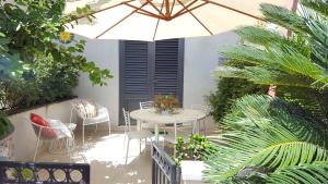 a patio with a table and chairs and an umbrella at Appartamento Verde Taormina in Taormina