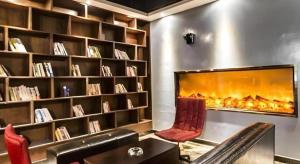 a living room with a fireplace in a library at James Joyce Coffetel Bozhou Tangwang Road in Bozhou