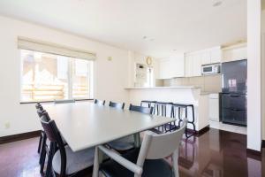 a kitchen with a table and chairs in a room at Yukisawa House in Kutchan