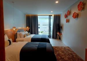 a hotel room with two beds and a window at La La Lay Beach House By Mukrada House 1 in Klong Muang Beach +27 photos
