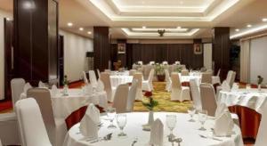a banquet hall with white tables and white chairs at Elmi Hotel in Surabaya +179 photos