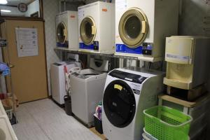 eine Waschküche mit Waschmaschine, Waschmaschine und Trockner in der Unterkunft Minpakushisetsu Nipopo - Vacation STAY 19564 in Fukagawa