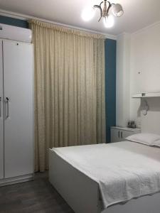 a bedroom with a large white bed and a window at Manija Hostel in Samarkand