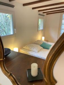a bedroom with a bed and a table with a candle at Charmant Mazet en campagne provencale in Châteaurenard