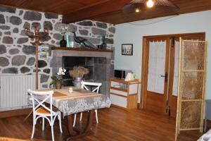 a dining room with a table and a stone wall at Chambre d’hôtes de Curières in Cheylade