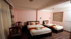 a hotel room with two beds in a room at De Hotel Veda in Kathmandu