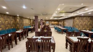 a restaurant with wooden tables and blue chairs at KAREEM RESIDENCY in Srinagar