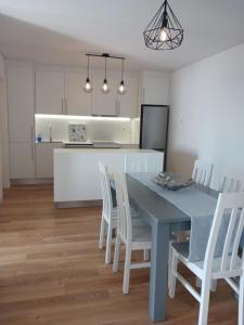 una cucina con tavolo blu e sedie bianche di Lagoa Princess Condo a Lagoa Altre 13 foto