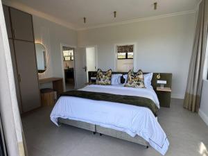 a large bedroom with a large bed with pillows at Plettenvale Wines in Plettenberg Bay
