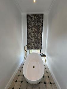 a white toilet in a room with a window at Plettenvale Wines in Plettenberg Bay