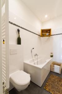 a white bathroom with a toilet and a tub at Apartment Vienna Your home abroad in Vienna