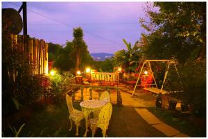 a backyard with a table and chairs and a swing at MAHABALESHWAR HERITAGE villa in Kelghar