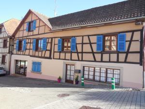 Epfig的住宿－Gîte Cerise & Coquelicot，上面有蓝色百叶窗的建筑