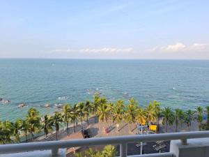 a view of a beach with palm trees and the ocean at Bangsaen Royal Beach Seaview Room in Ban Laem Thaen
