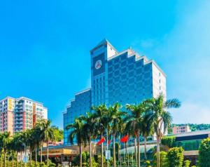 TiantangweiにあるFenggang Gladden Hotelのヤシの木が前に生えている高い建物