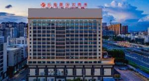 een hoog gebouw met een bord erop bij Foshan Jubilee Hotel in Pingzhou