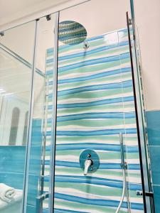 una ducha con puerta de cisne en un baño en Civico27, en SantʼAntonio Abate