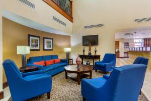 a living room with blue couches and a table at Comfort Suites Charleston West Ashley in Charleston