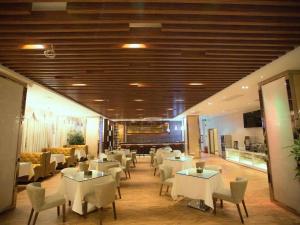 een eetkamer met witte tafels en stoelen bij Zhonglian Harbor Hotel in Shanwei