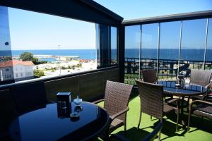 a balcony with tables and chairs and a view of the ocean at Seref Hotel in Yalova