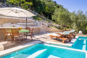 un patio con mesa y sillas junto a una piscina en Villa Miolin, en Trpanj