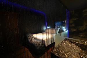 Zimmer mit einer Spiegelung eines Bettes in einem Fenster in der Unterkunft L'amour Hotel in Ho-Chi-Minh-Stadt