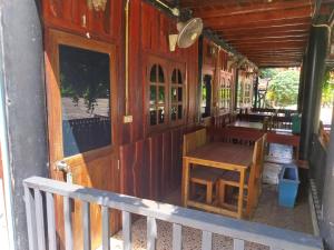 a wooden porch with a wooden table and benches at Bamboo River House Kaengkrachan in Ban Nong Chaeng