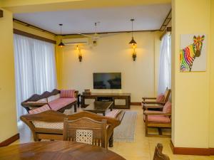 a living room filled with furniture and a flat screen tv at AfroHaki Homes in Mombasa