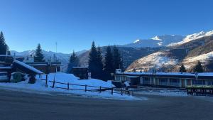a building with snow on the ground next to a mountain at Suite Albare, Marilleva 1400, Val di Sole in Marilleva