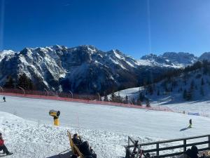 a group of people sitting on a ski slope in the snow at Suite Albare, Marilleva 1400, Val di Sole in Marilleva