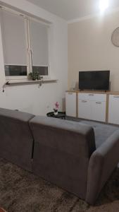 a living room with a couch and a flat screen tv at Apartament 35m2 in Koszalin