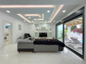 ein großes Wohnzimmer mit einem Bett und einem Fernseher in der Unterkunft Diamond Luxury Villa Corfu in Káto Spílaion