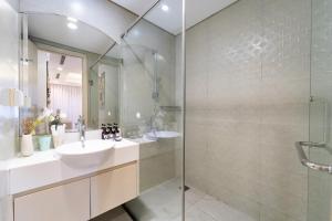 a bathroom with a sink and a glass shower at Landmark Signature Residences Ori-Stay in Kon Rung (1) +258 photos