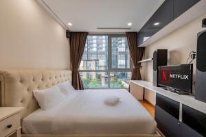 a small bedroom with a bed and a television at Landmark Signature Residences Ori-Stay in Kon Rung (1)