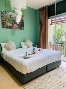 a bedroom with a large bed with red flowers on it at Alura Guesthouse in Kata Beach