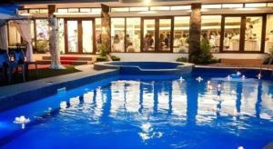 DiniginanにあるIslands Hotelの建物の前の青い水の大きなプール