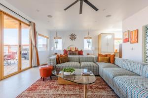 een woonkamer met een bank en een glazen tafel bij Retro Vibes, Pool, Spa & Game Room in Twentynine Palms