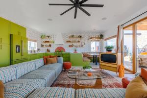 een woonkamer met een blauwe bank en een tv bij Retro Vibes, Pool, Spa & Game Room in Twentynine Palms