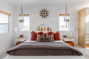 een slaapkamer met een groot bed met oranje kussens bij Retro Vibes, Pool, Spa & Game Room in Twentynine Palms