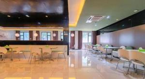 a restaurant with tables and chairs in a room at Jinjiang Inn Xiamen Railway Station in Xiamen